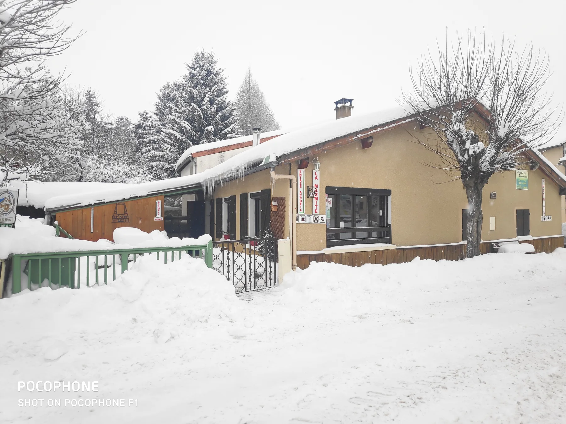 Representative hotel space: A low building with snow-covered roofs stands beside a snow-covered road.