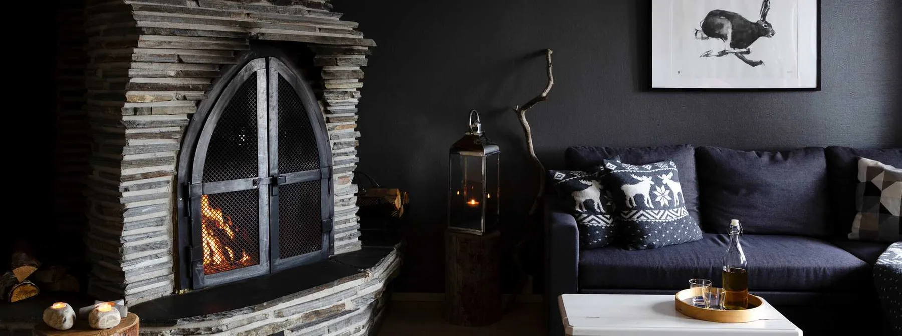Representative hotel space: A dark lounge with a stone fireplace and a sofa.