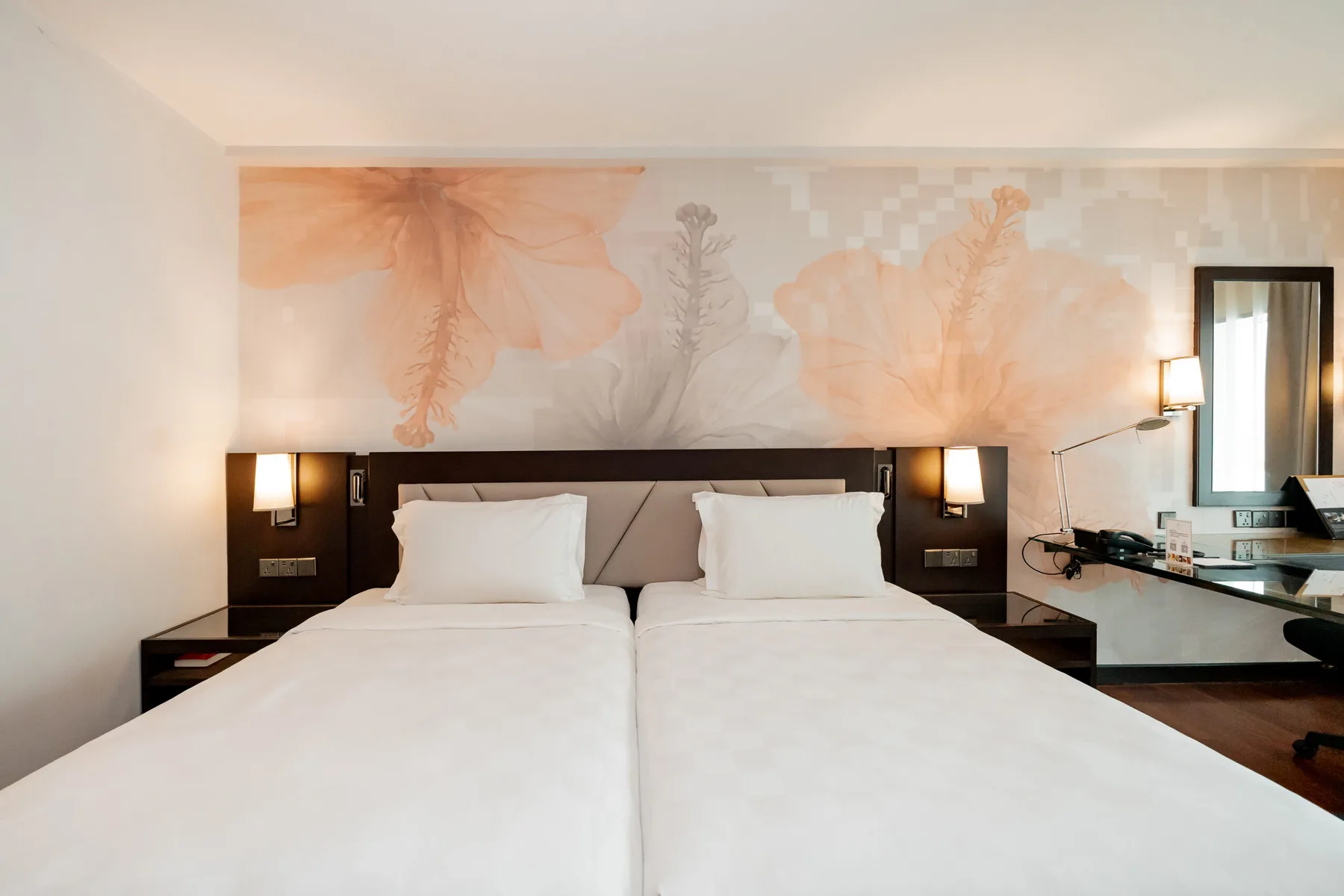 Representative hotel space: A hotel bedroom with two beds and floral wall artwork.