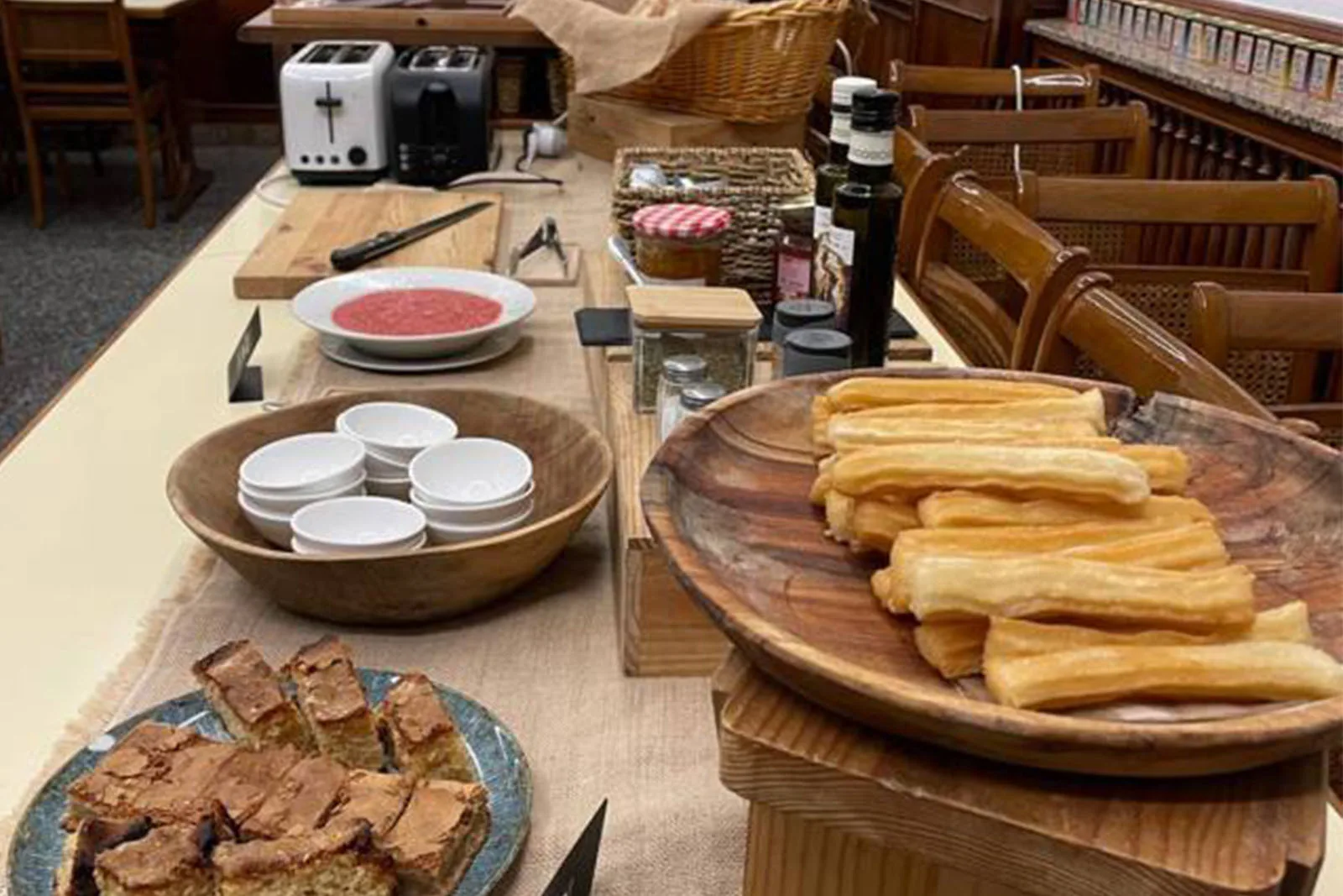 Espacio representativo del hotel: Una mesa de comedor exhibe pasteles, cuencos y otros alimentos.