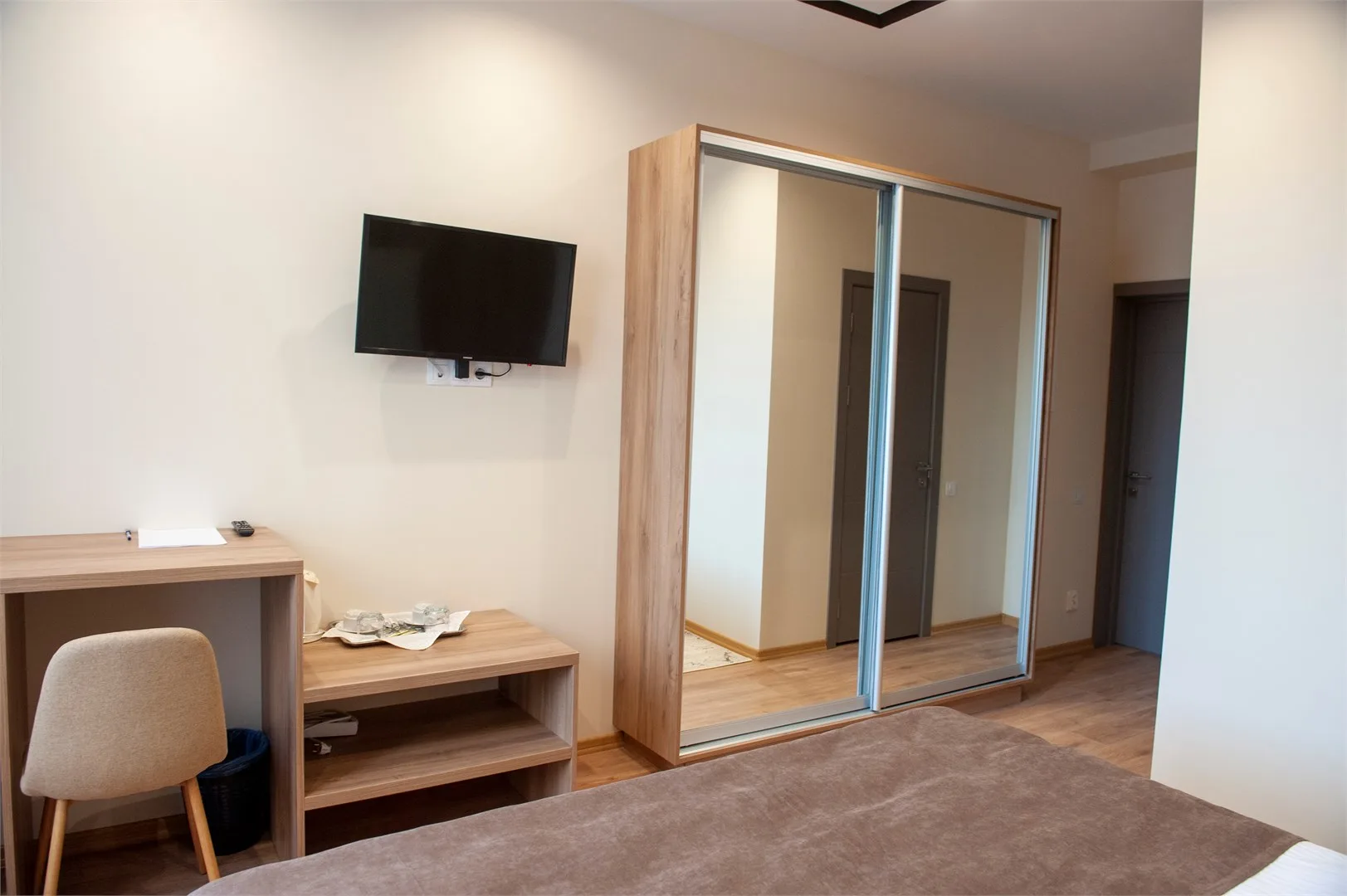 Espacio representativo del hotel: Un dormitorio con cama, escritorio y armario con espejo.
