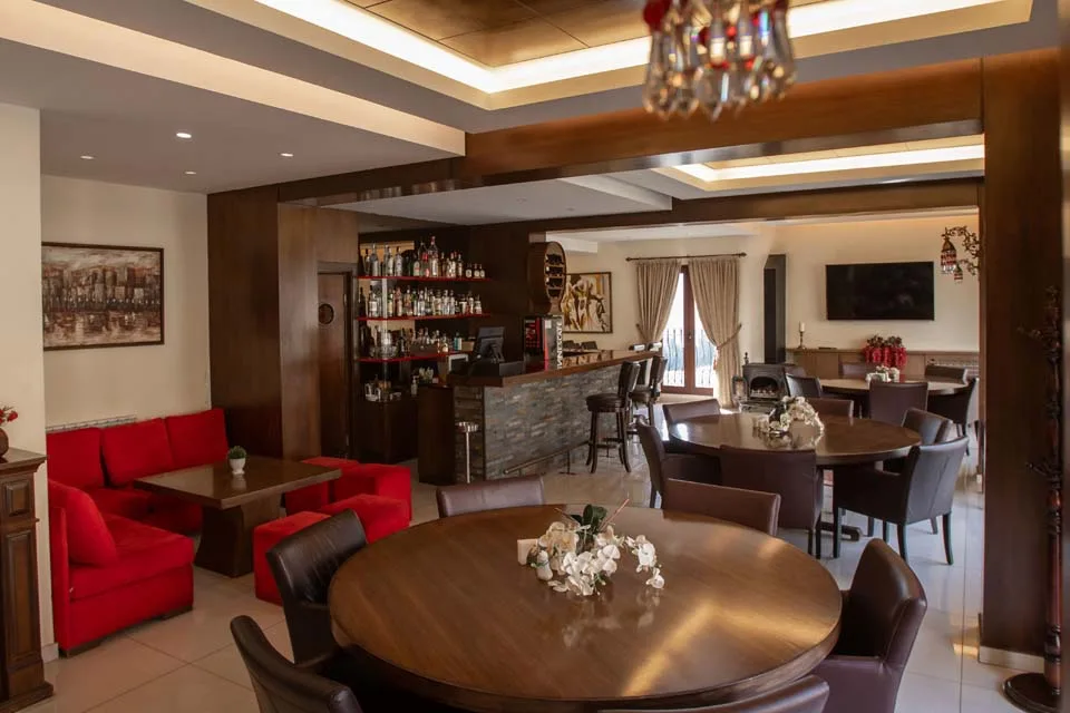 Representative hotel space: A dining area with tables and seating beside a bar.
