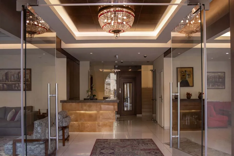 Representative hotel space: A hotel lobby entrance with a reception desk and chandelier.