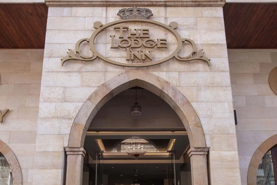 Representative hotel space: Hotel entrance framed by a large stone arch and an ornate sign.