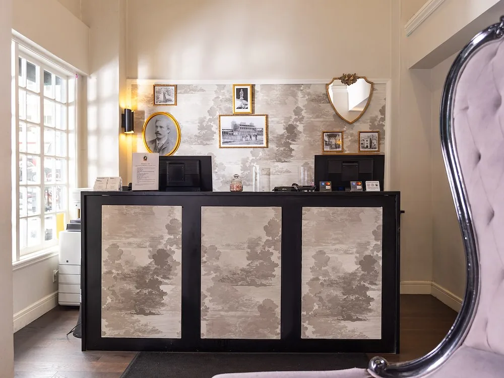 Representative hotel space: Hotel reception desk with framed artwork and large windows.