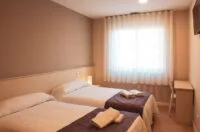 Representative hotel space: A bedroom with two beds and a bright window.