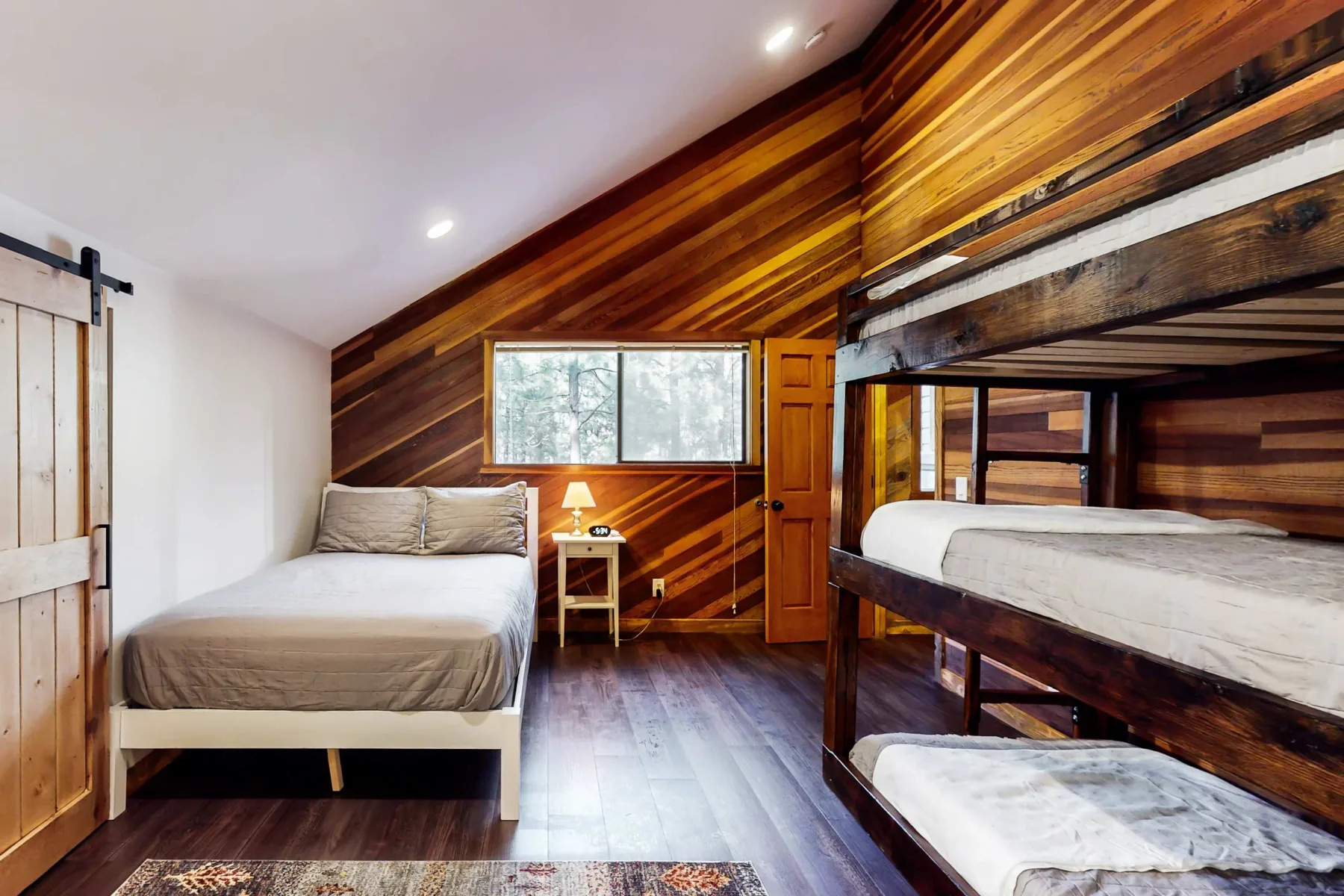 Un dormitorio con una cama, una ventana y una litera de madera.