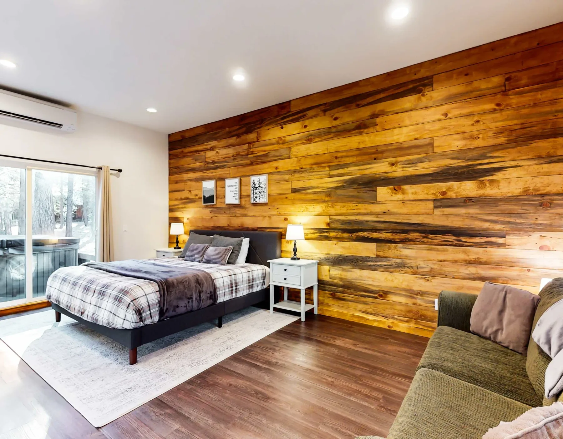 Dormitorio con una cama junto a una gran pared revestida de madera.