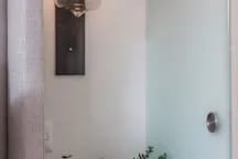 A shower area with a glass panel and a wall-mounted fixture.