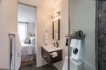 A bedroom with a bed and an adjoining bathroom.