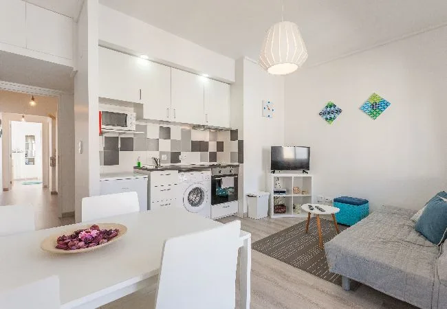 Una luminosa sala de estar y cocina de concepto abierto con mesa de comedor y asientos.