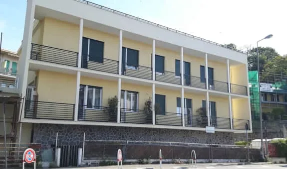Espacio representativo del hotel: Edificio de tres plantas con filas de ventanas y barandillas en los balcones.