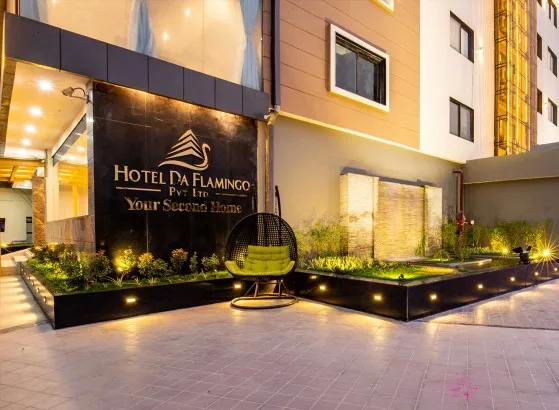 Espacio representativo del hotel: Entrada exterior del hotel con jardines iluminados y una silla colgante.