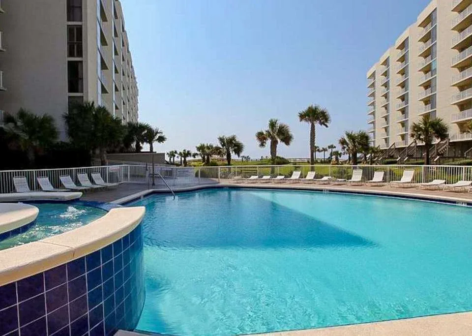 Zona común: Una piscina al aire libre está entre dos edificios altos.
