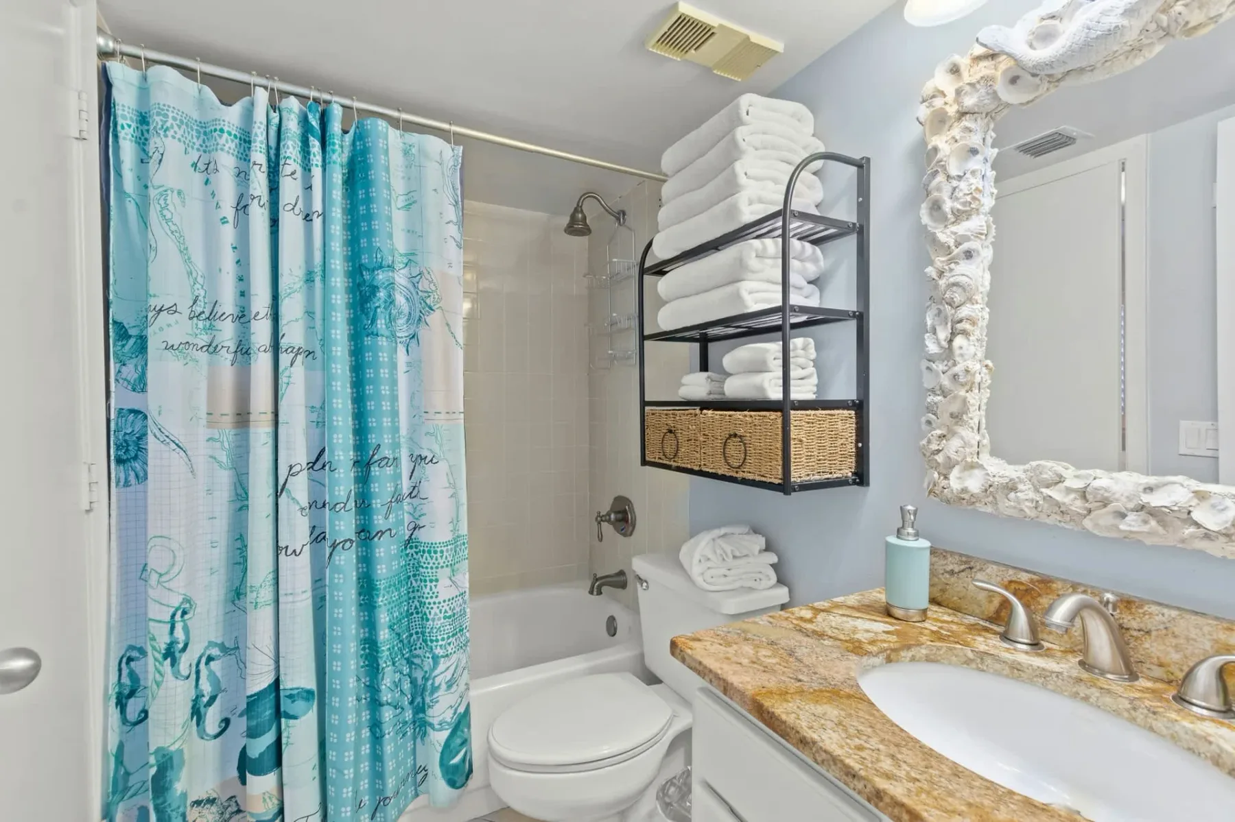 Un baño con bañera, cortina de ducha, inodoro y lavabo.