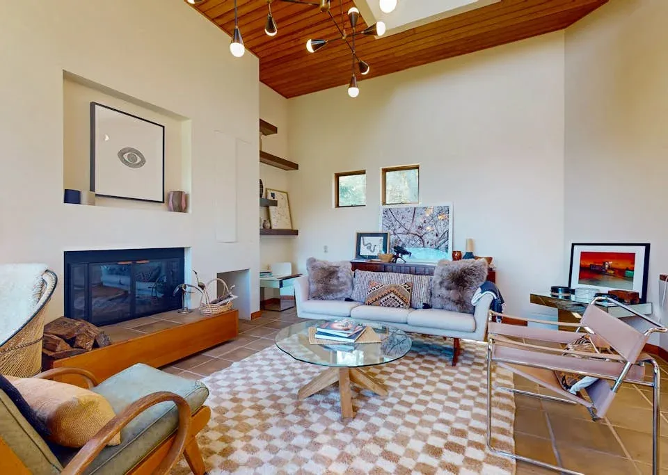 A bright living room with a fireplace, seating, and a glass coffee table.