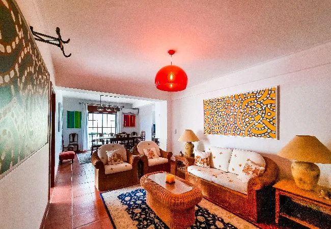 Una sala de estar con asientos alrededor de una mesa baja y arte colorido en las paredes.