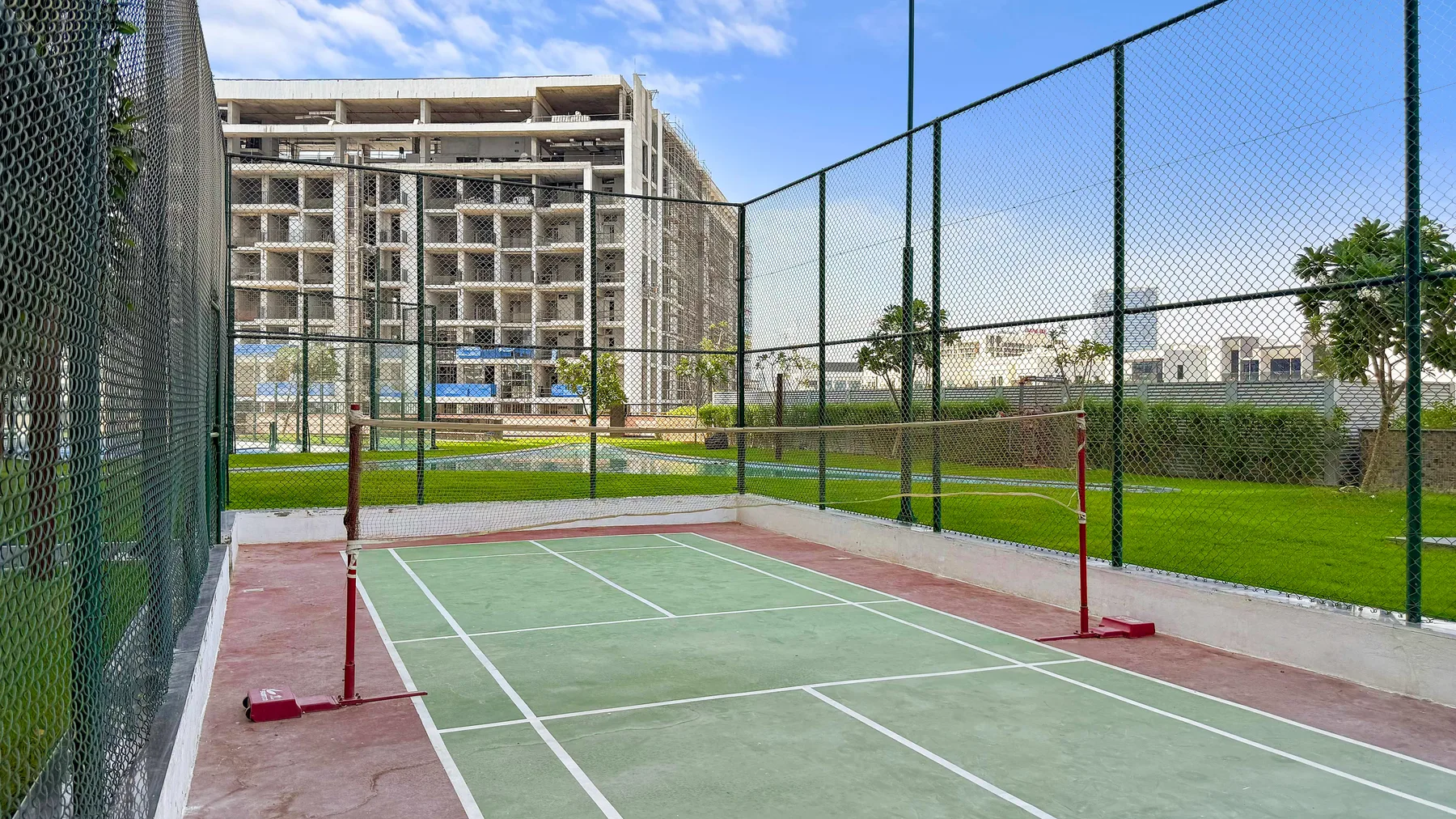 Zona común: Una cancha deportiva al aire libre con superficie verde y vallas alrededor.