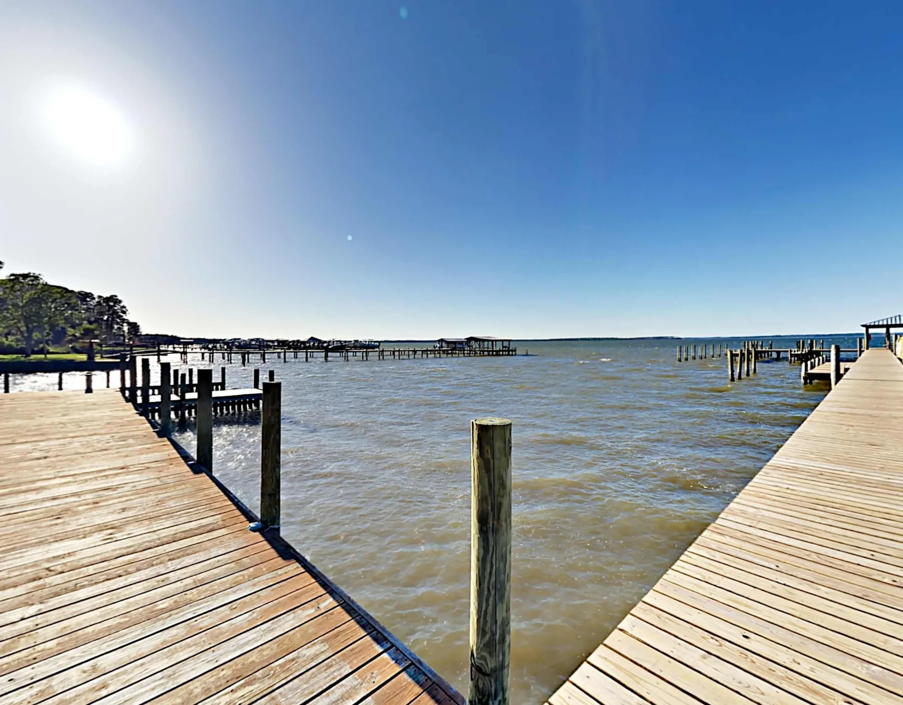 Zona común: Un muelle de madera se extiende sobre el agua bajo un cielo despejado.