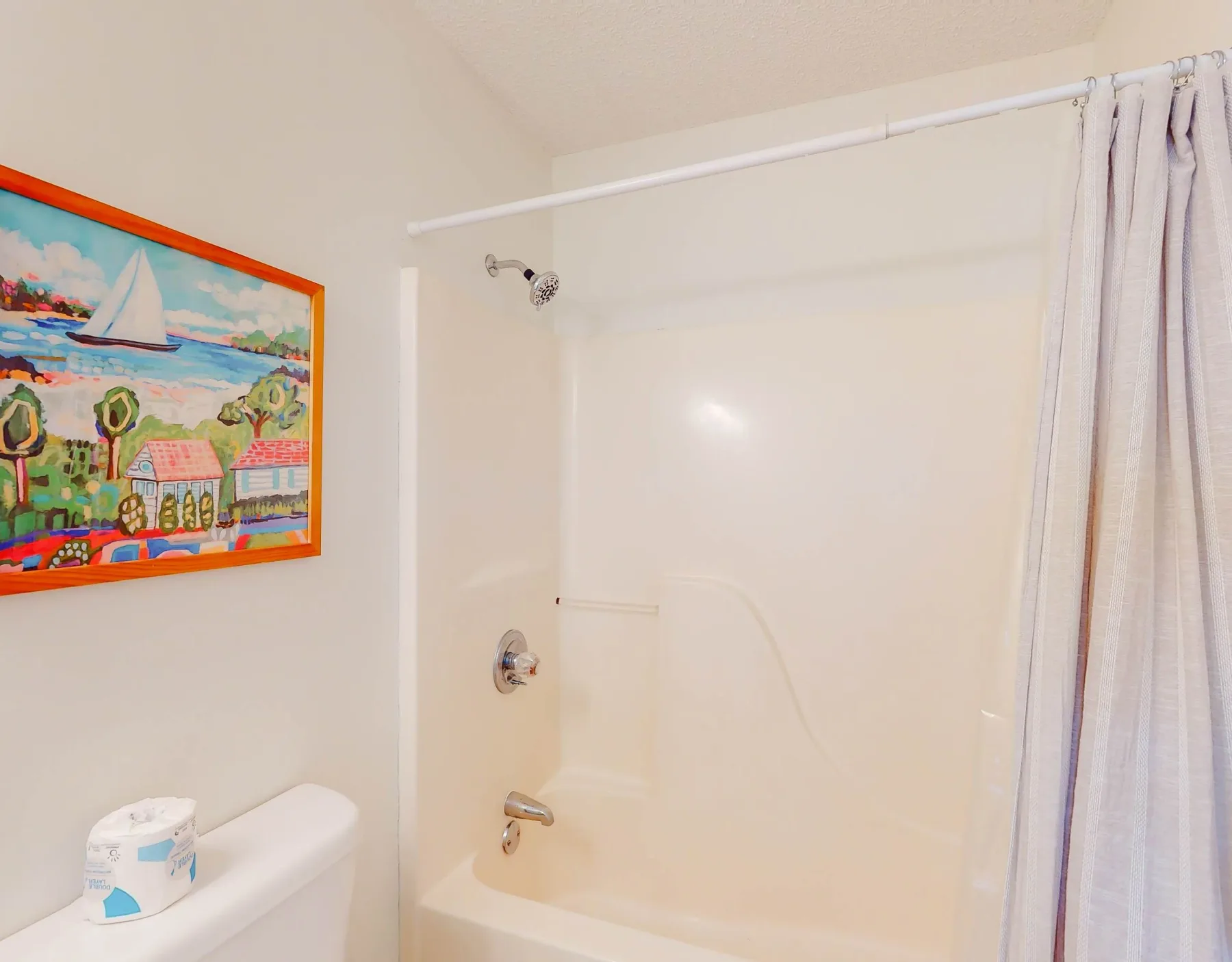 Un baño con bañera y ducha detrás de una cortina.