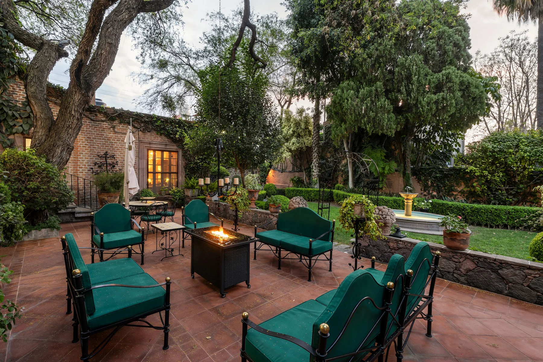 A garden patio with outdoor seating and a small fire table.