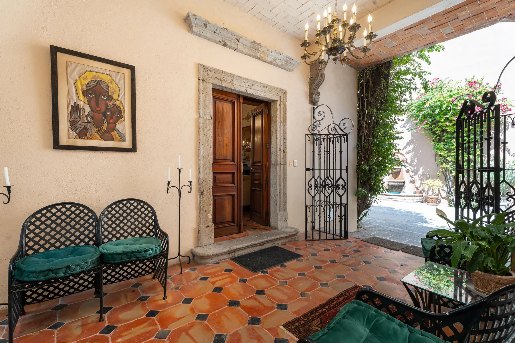 An entryway opens onto a garden courtyard, with patterned tile flooring and lattice seating.