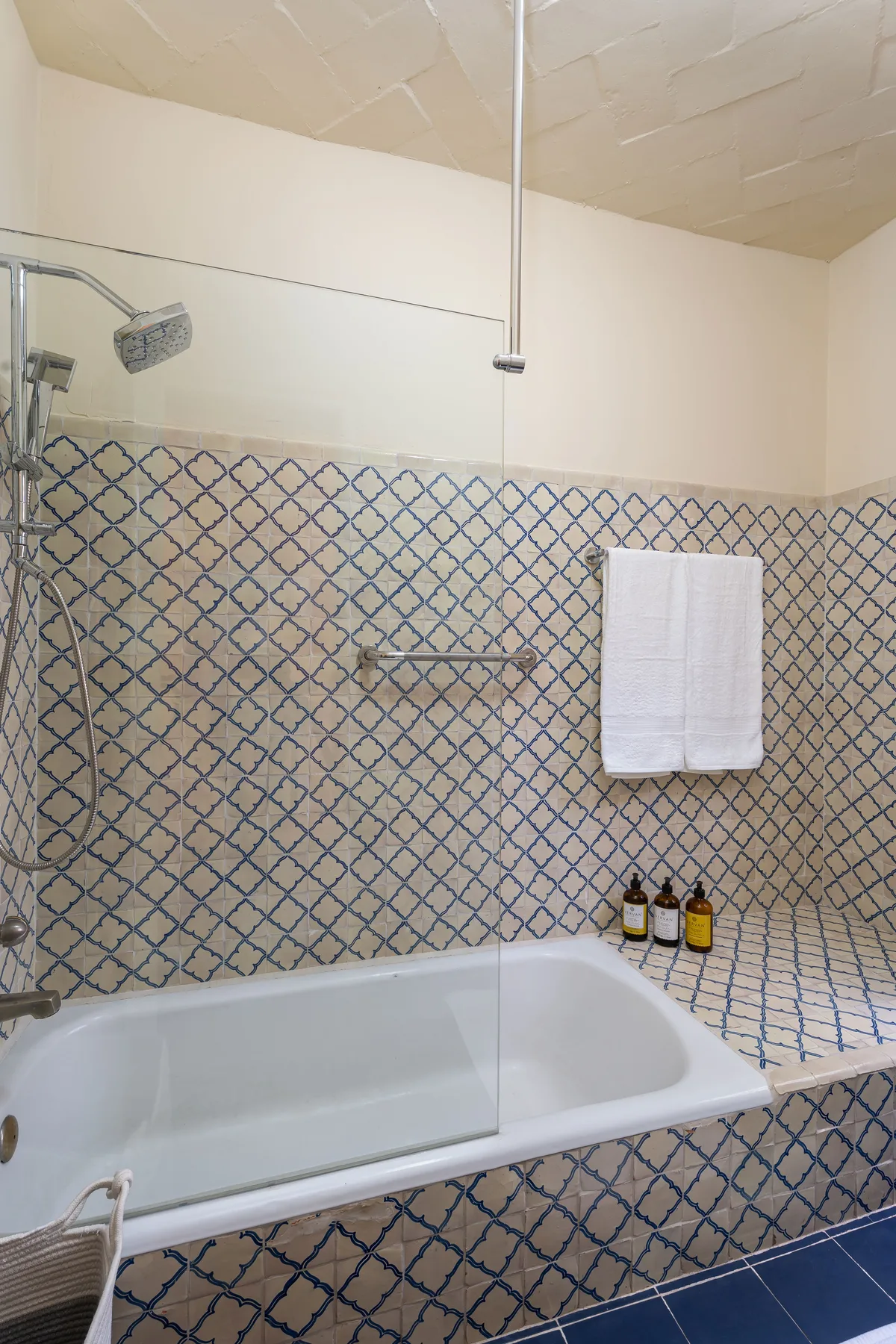 A tiled bathroom with a bathtub and shower fixtures.