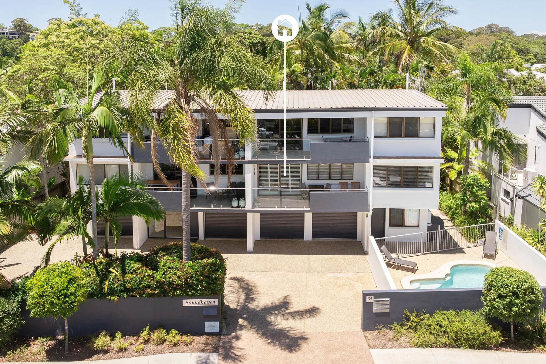Shared amenity: A multi-story building with balconies stands beside a swimming pool.