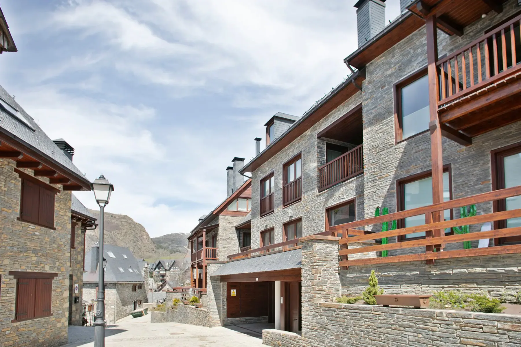 Shared amenity: A paved lane runs between stone buildings with wooden balconies.