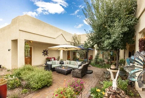 Representative hotel space: A landscaped courtyard patio with outdoor seating beneath a shade umbrella.