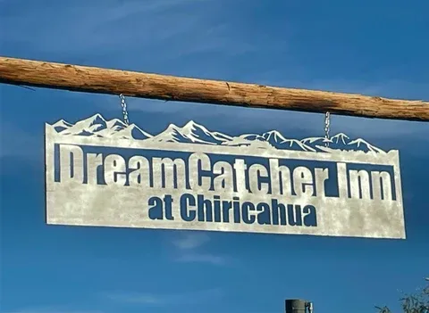 Representative hotel space: A hanging sign reads “Dream Catcher Inn at Chiricahua” against a blue sky.