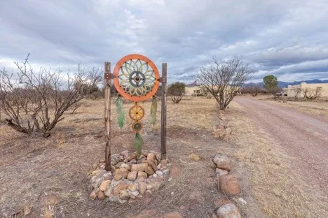 Representative hotel space: A rural dirt road passes a decorative circular sculpture in a dry landscape.
