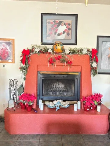 Representative hotel space: A decorated fireplace with holiday greenery, flowers, and framed artwork.