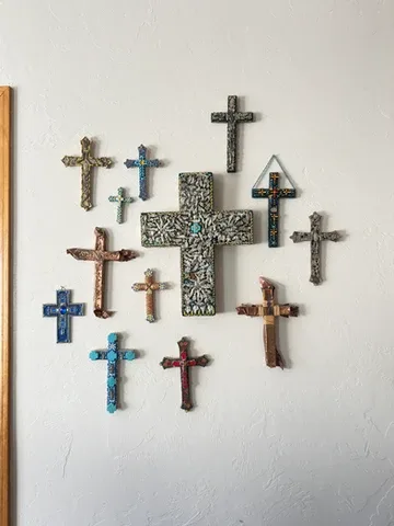 Representative hotel space: A wall display of decorative crosses in varied colors and designs.
