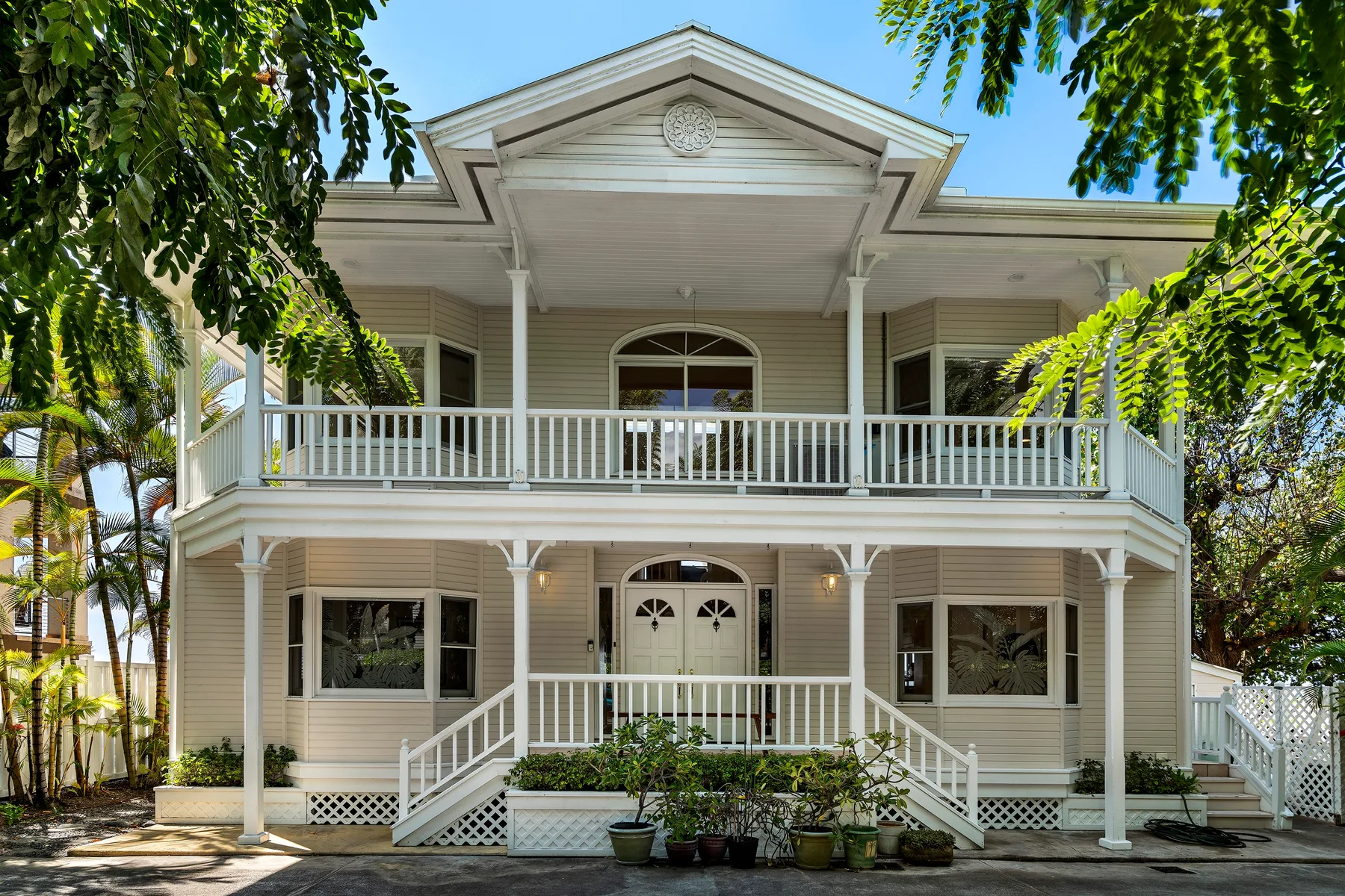 A two-story house with a broad front porch and white railings.