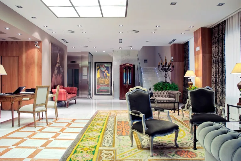 Espacio representativo del hotel: Un vestíbulo de hotel ornamentado con alfombras estampadas y asientos tapizados.