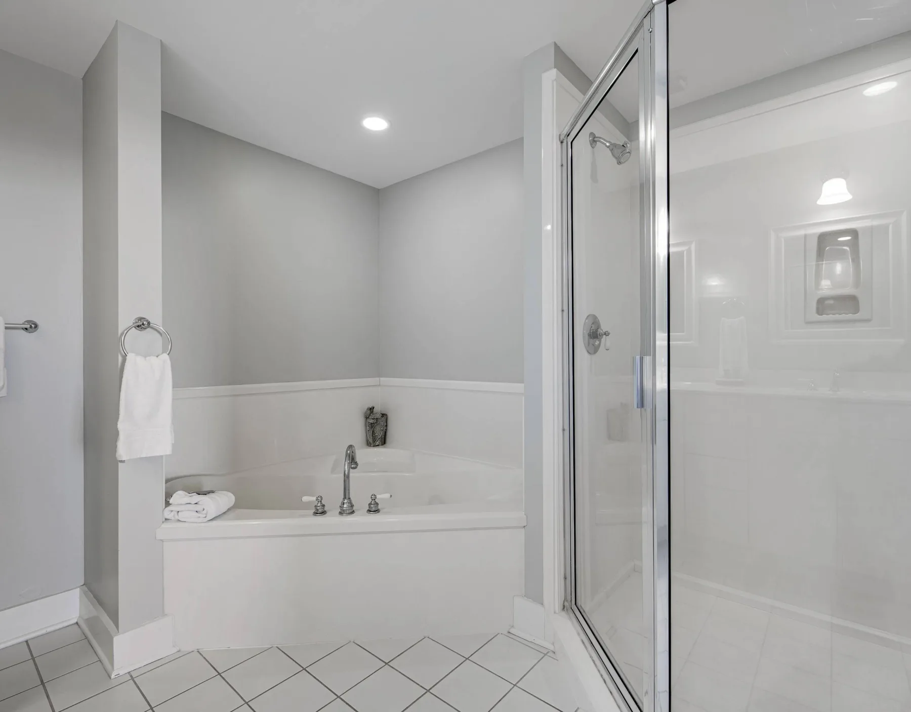 A bright bathroom with a bathtub and a glass-enclosed shower.