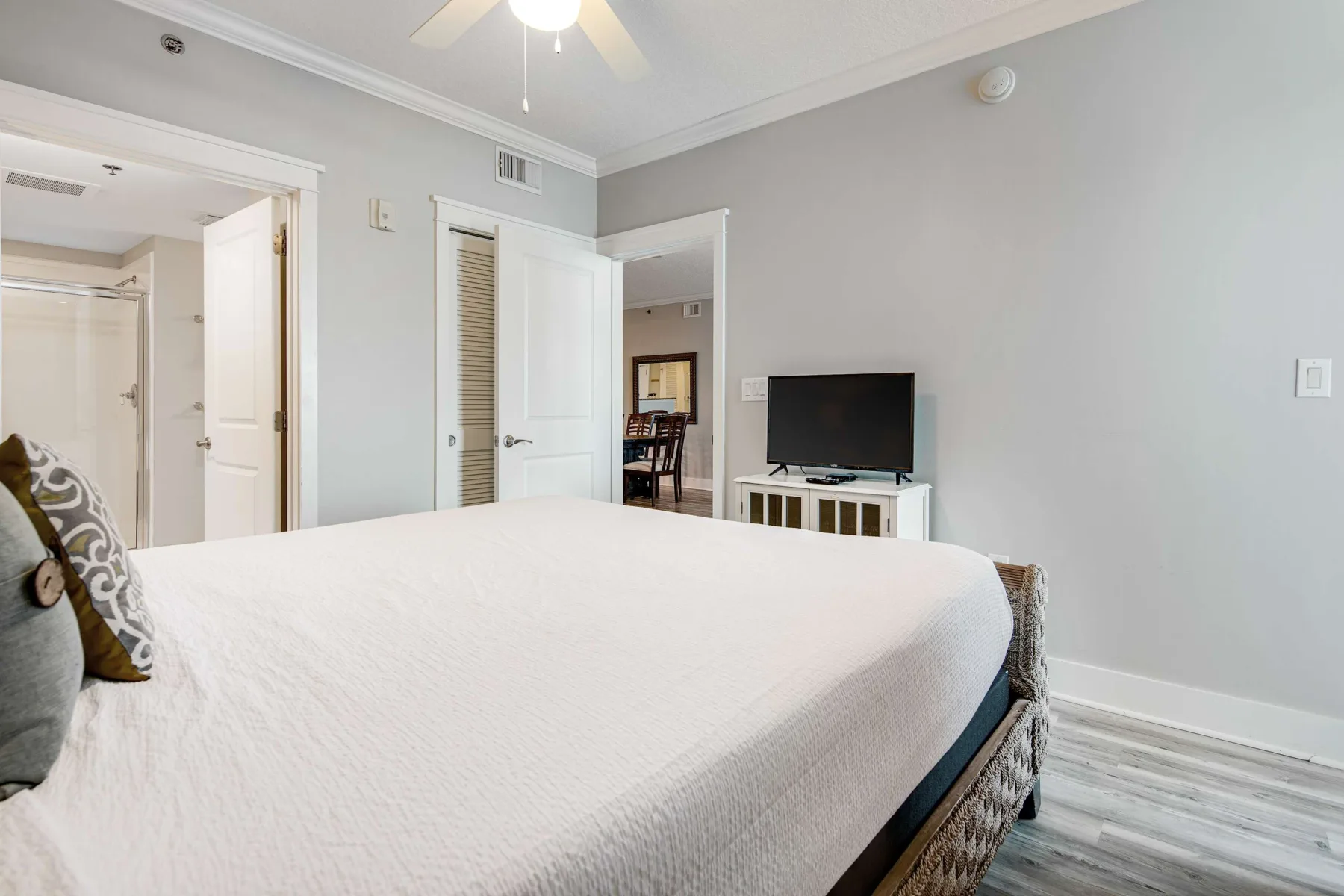 A bedroom with a large bed and a television on a stand.