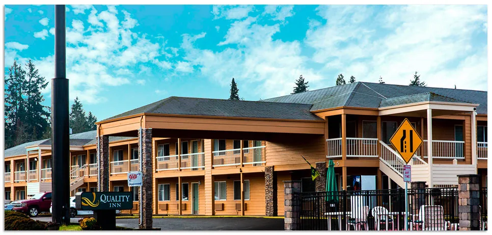 Representative hotel space: A multi-story hotel building with wooden balconies stands beside a street.