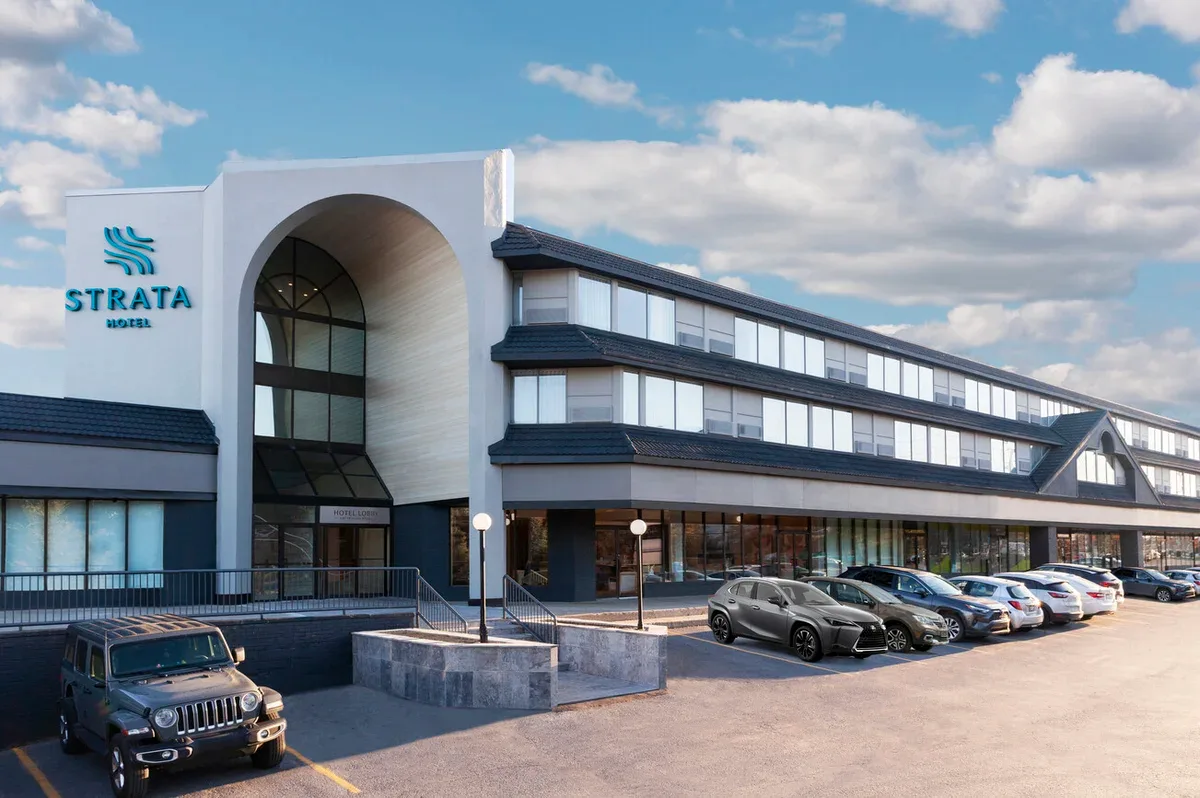 Representative hotel space: The Strata Hotel exterior shows a curved entrance and a row of parked cars.