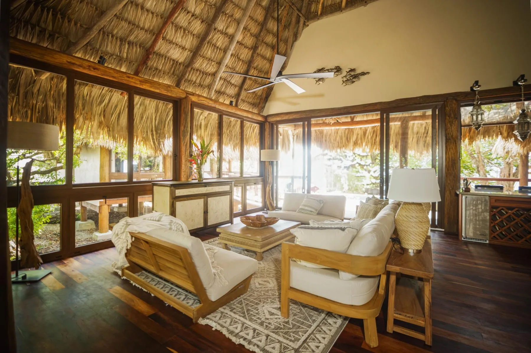 A bright living room has light-colored seating arranged around a wooden coffee table.