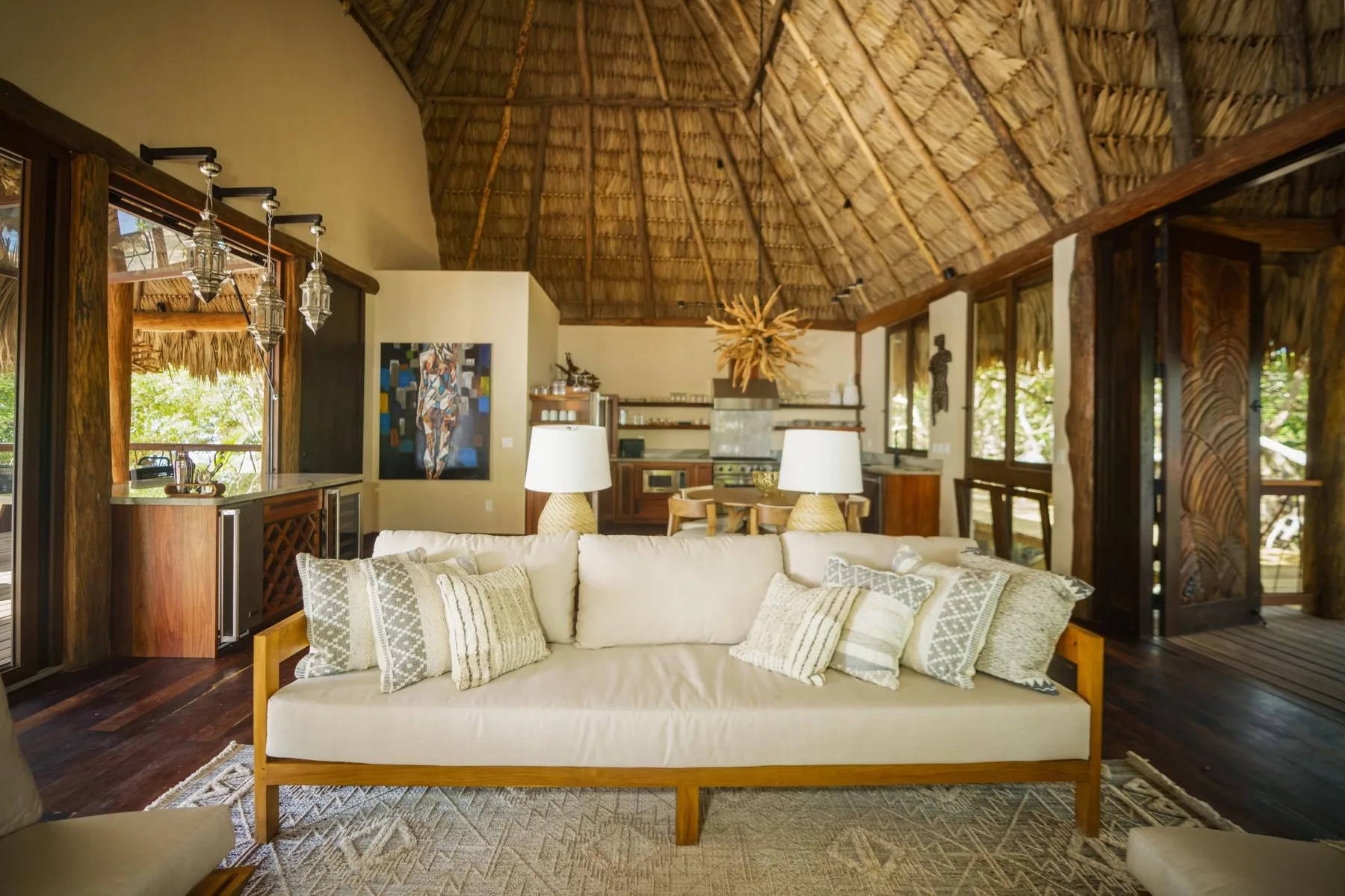 A living room with a sofa beneath a high thatched ceiling.