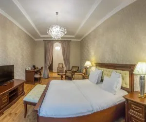 Representative hotel space: A hotel bedroom with a large bed, bedside tables, and a chandelier.