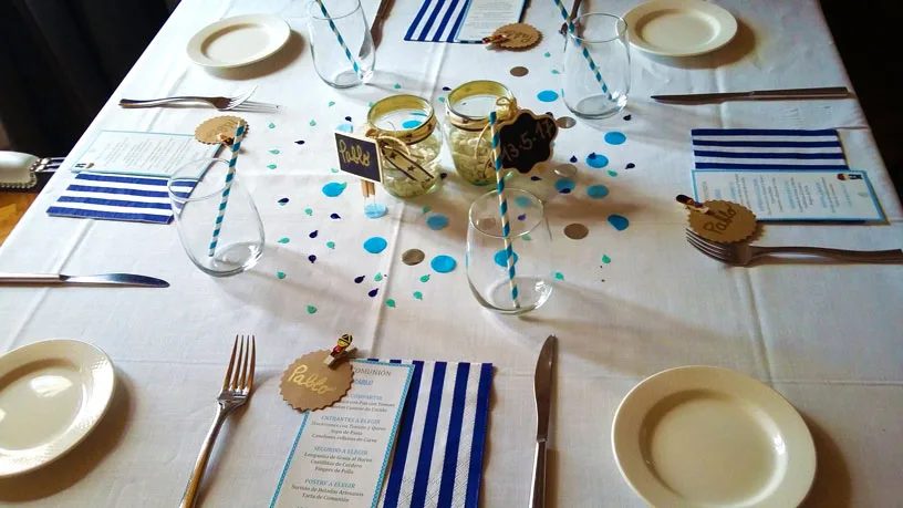 Espacio representativo del hotel: Una mesa decorada está preparada con platos, vasos y servilletas a rayas.