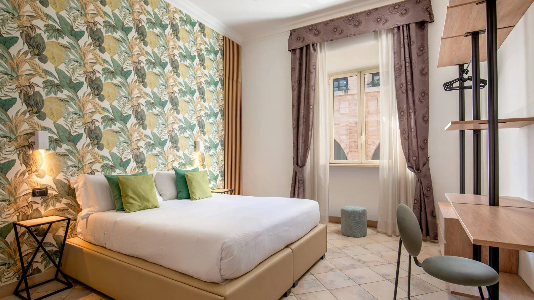 Espacio representativo del hotel: Un dormitorio con una cama, papel pintado estampado y una ventana.