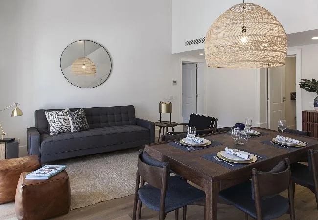A living and dining area with a dark sofa and a set dining table.