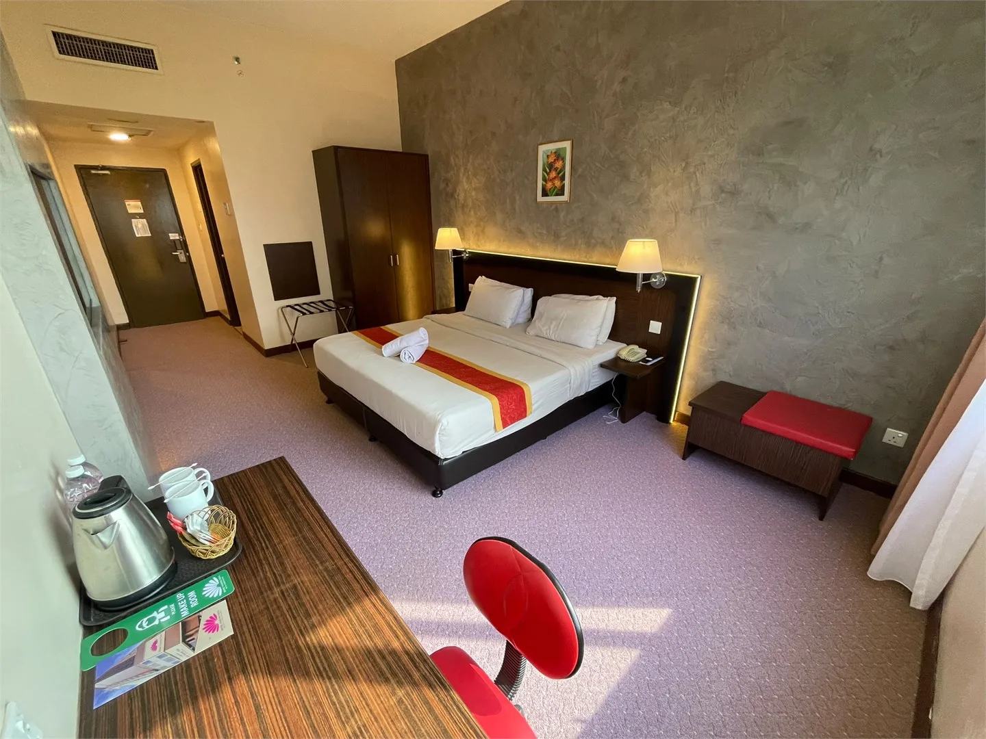 Representative hotel space: A hotel bedroom with a double bed, bedside lamps, and a desk.