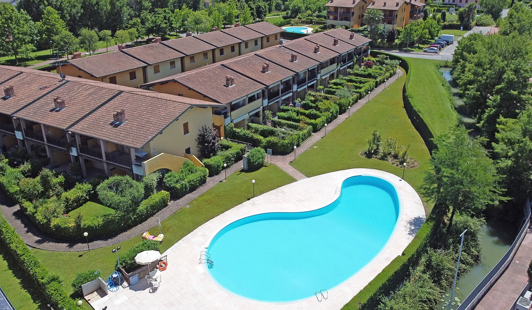 Zona común: Vista aérea de una piscina junto a una hilera de edificios residenciales.