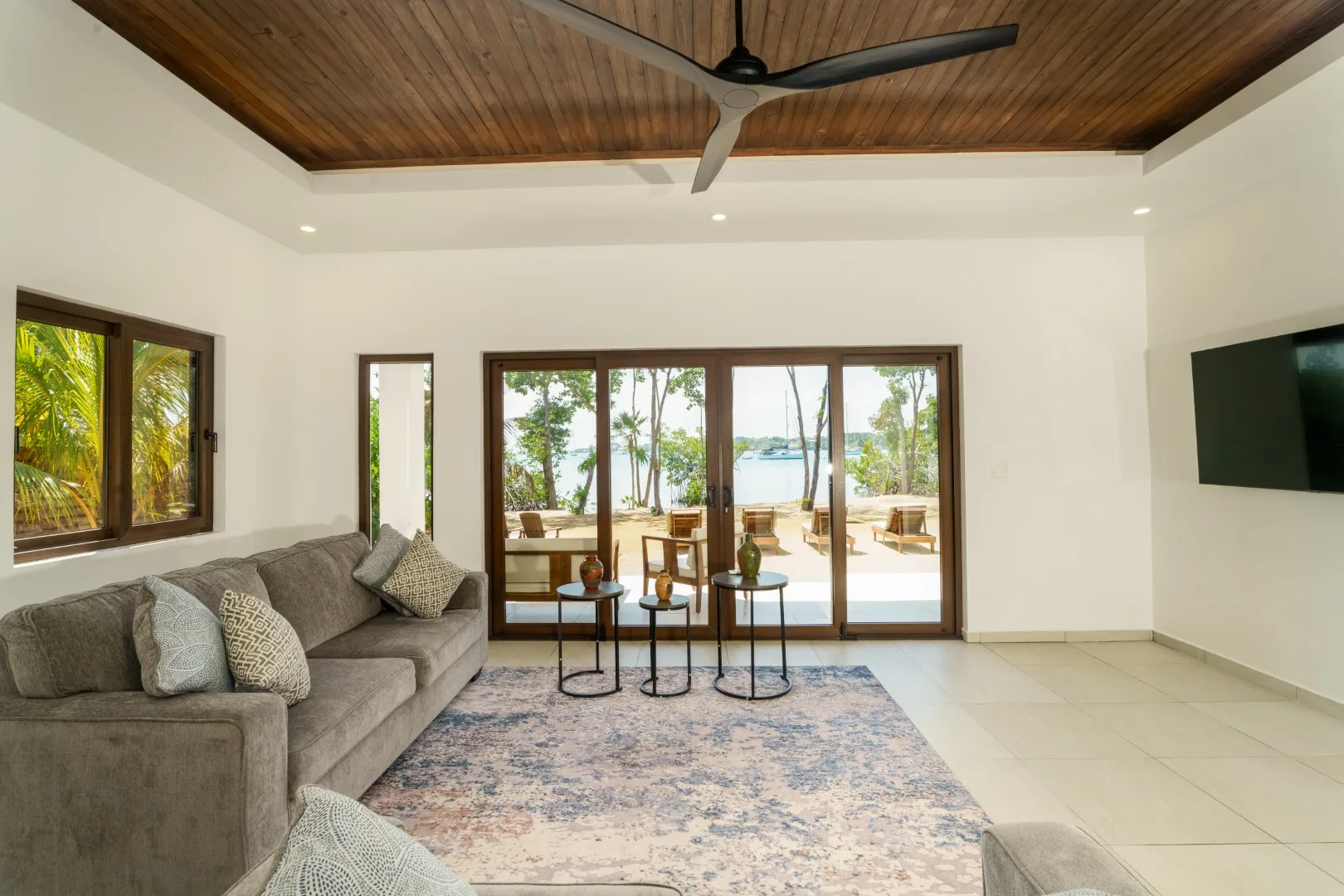 A living room with seating, a rug, and glass doors opening to a patio.