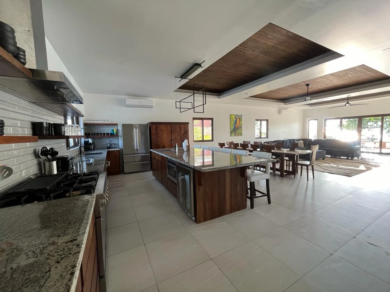 An open kitchen and dining area with a central island and large windows.
